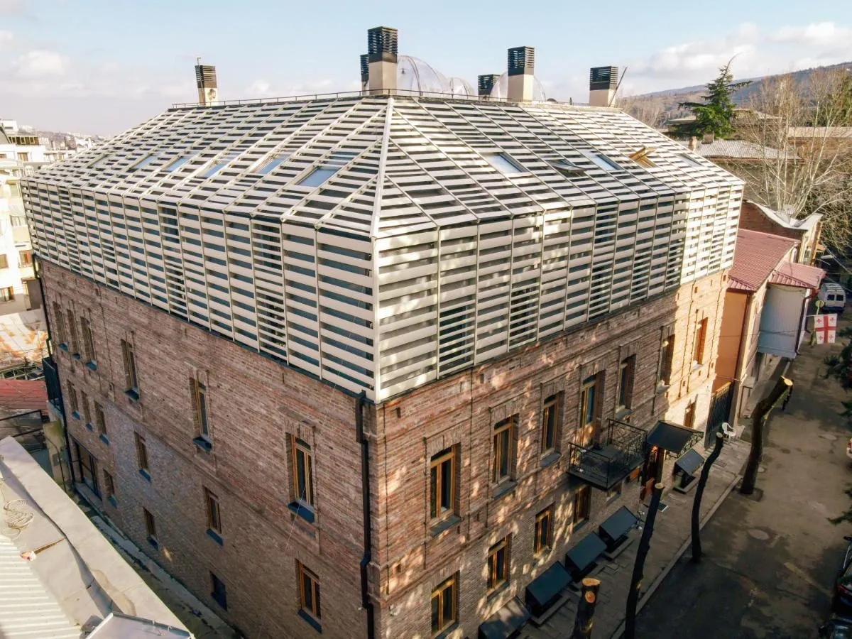 The hotel from above: old brick walls under a white louvred roof